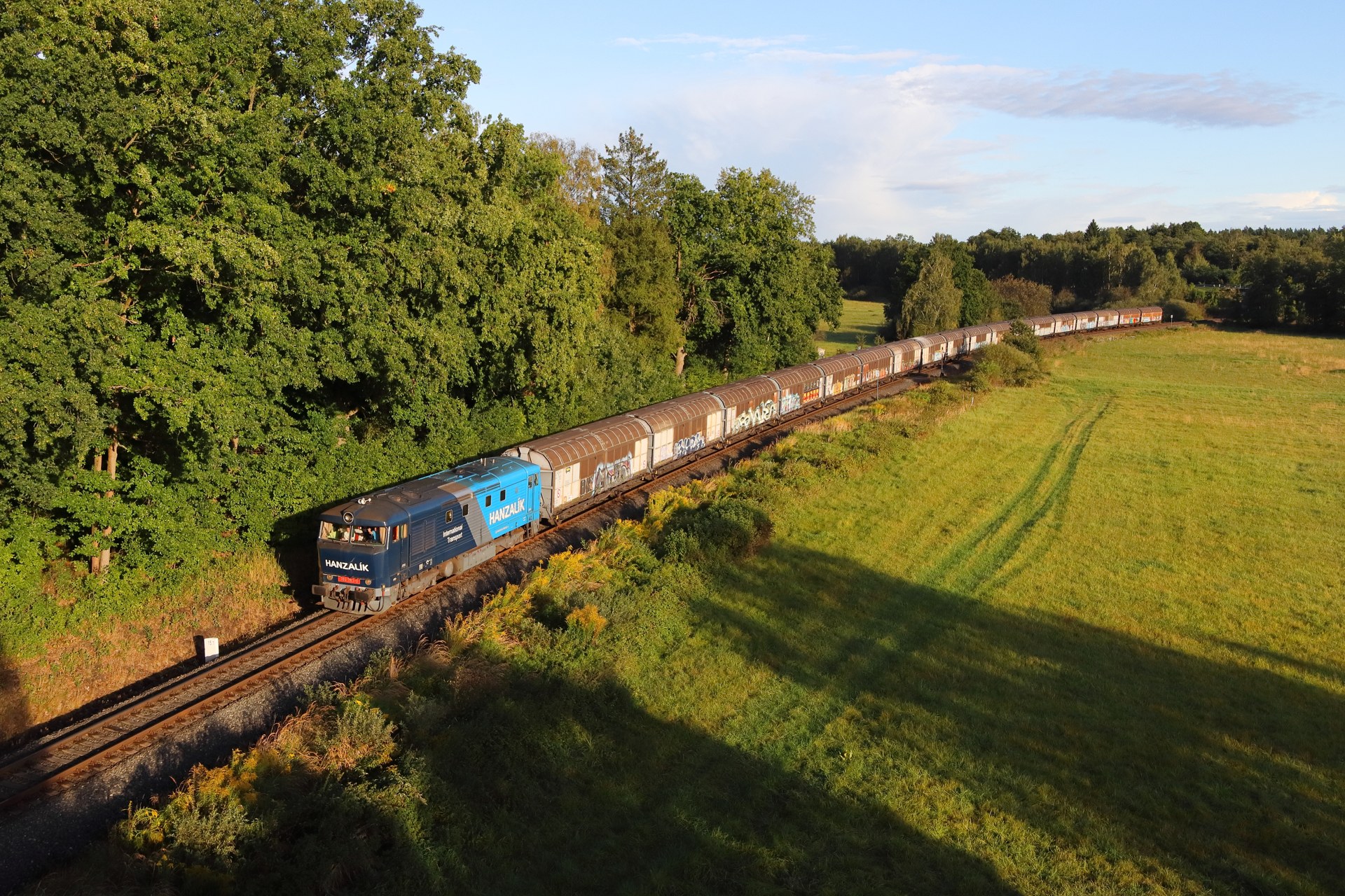 Lokomotiva Rail System s vlakovou soupravou v české krajině